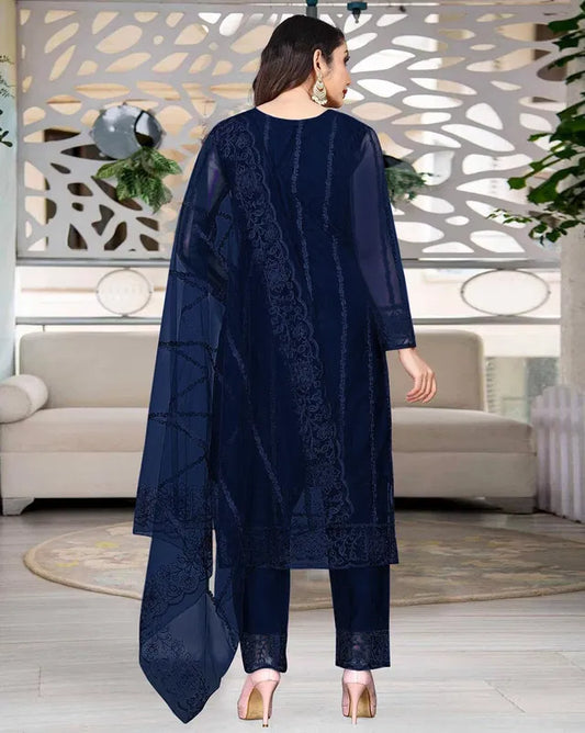 Woman wearing a navy blue ethnic suit with intricate embroidery and sheer dupatta, showcasing premium fabric quality and elegant traditional design.