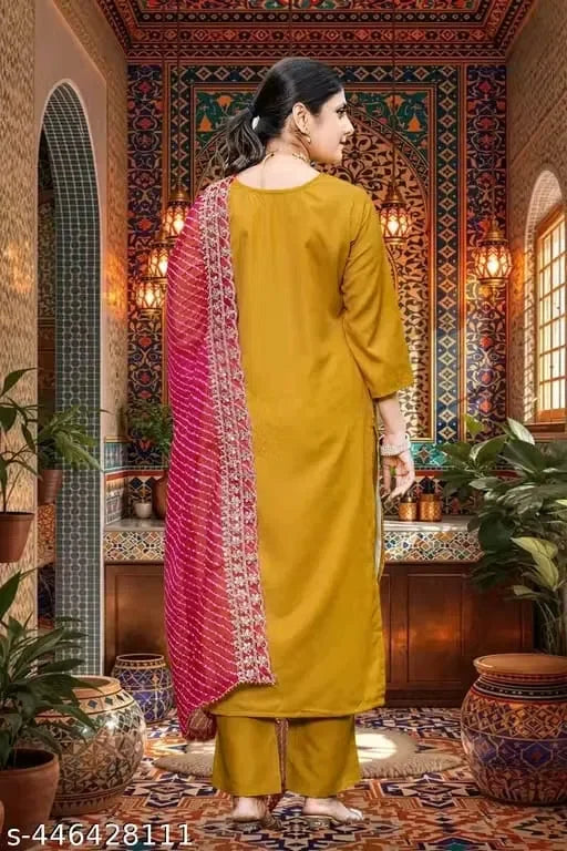 Woman in mustard yellow ethnic suit with pink embellished dupatta, premium fabric, ornate decor