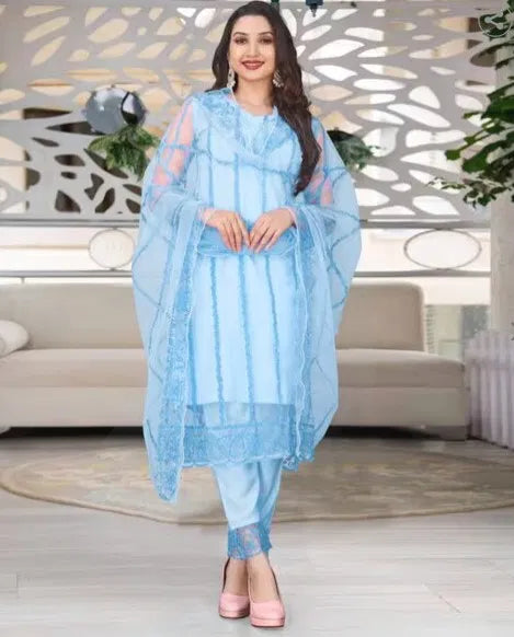 Woman wearing premium light blue rayon kurti set with sheer dupatta and ethnic embroidery.