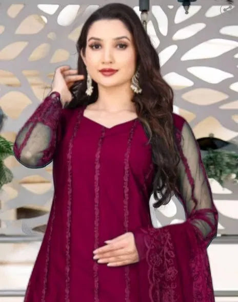 Woman in premium maroon rayon kurti set with sheer sleeves and intricate ethnic embroidery.