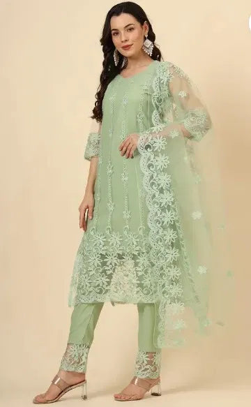 Woman in premium pastel green embroidered ethnic suit with sheer floral dupatta, showcasing fine fabric quality and elegant ethnic design.