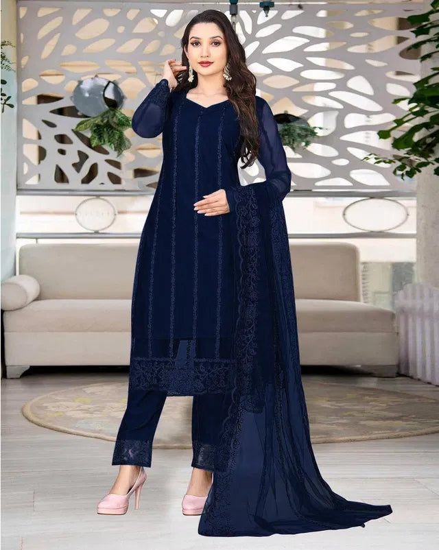 Woman in premium navy blue ethnic suit with sheer dupatta, showcasing fine fabric quality and elegant embroidery.
