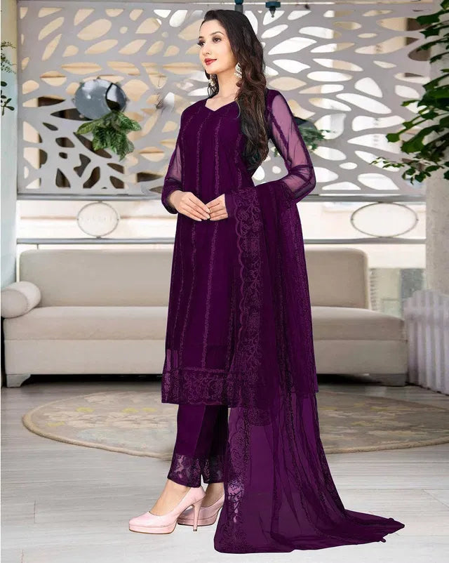 Woman in premium purple ethnic suit with sheer dupatta, showcasing fine fabric and elegant design