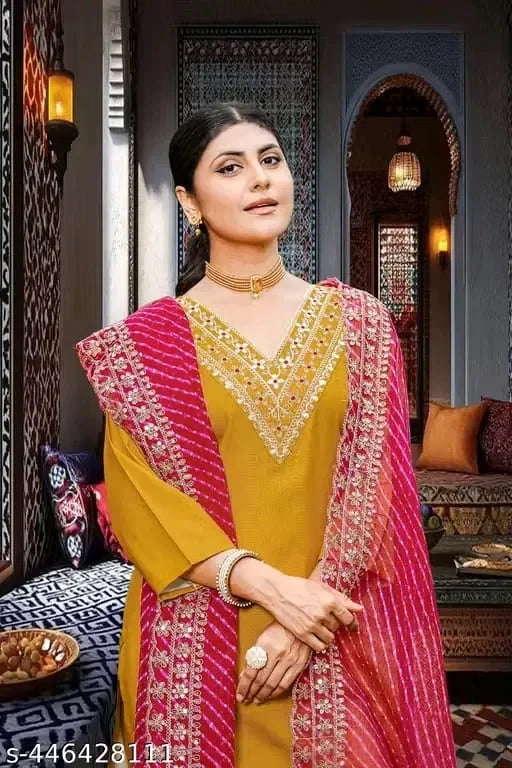 Premium mustard ethnic suit with intricate embroidery, featuring a pink dupatta and luxurious fabric quality.