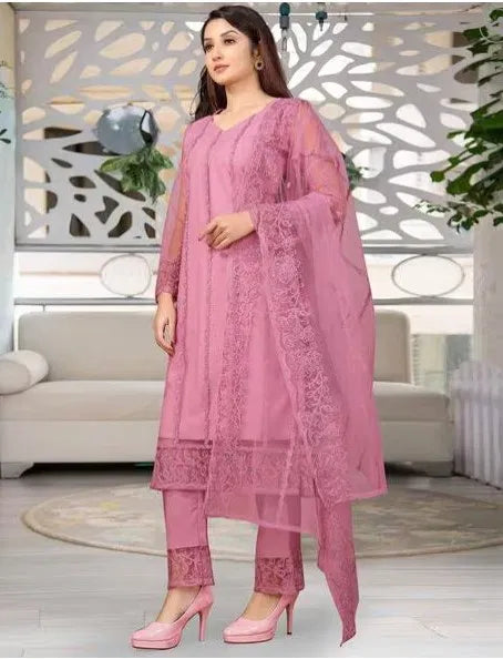 Woman wearing premium pink rayon kurti set with intricate ethnic embroidery in a modern living room