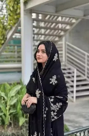 Woman wearing premium black rayon ethnic suit with white embroidery, showcasing elegant design