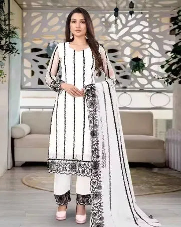 Woman wearing premium white ethnic suit with black embroidered patterns and matching dupatta, showcasing high-quality fabric and elegant traditional design.