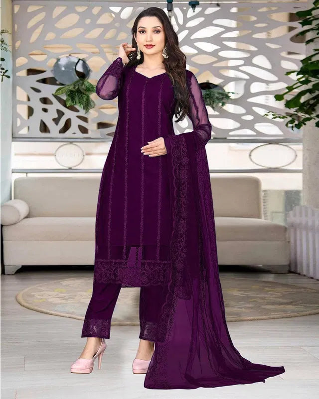 Woman wearing elegant purple ethnic suit with sheer sleeves, showcasing premium fabric quality and intricate embroidery.